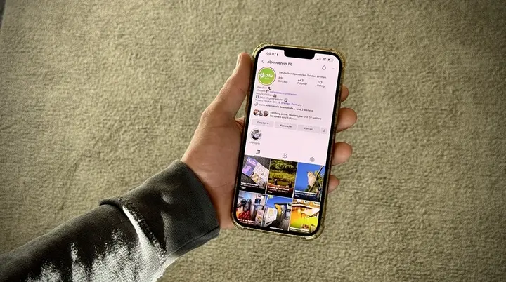 Hand hält Smartphone auf dem der Instagram-Account der Sektion angezeigt wird | © DAV Bremen
